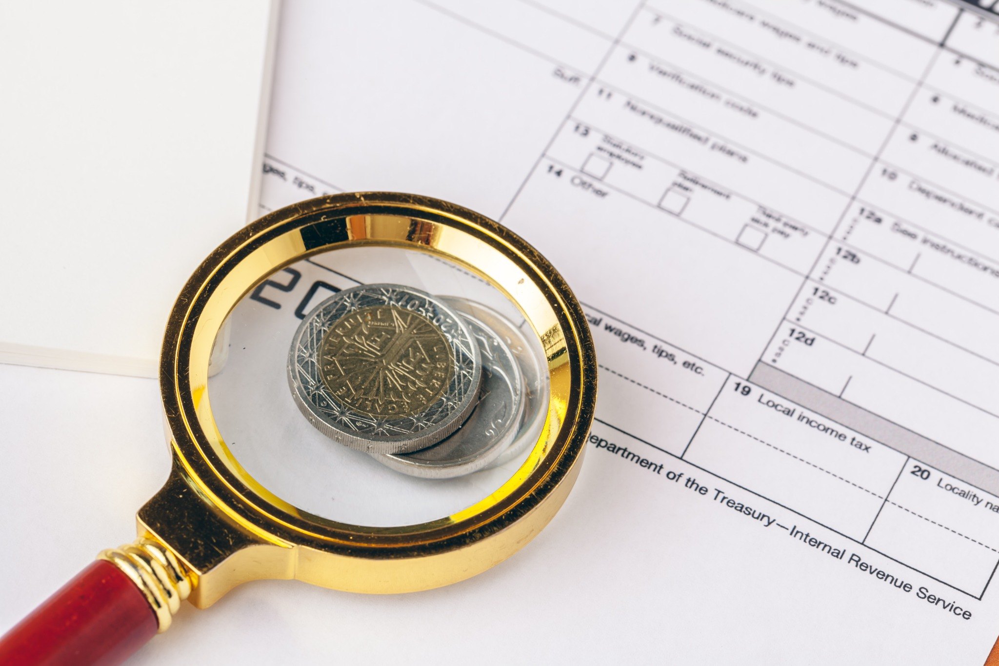 Magnifying glass reviewing a tax form