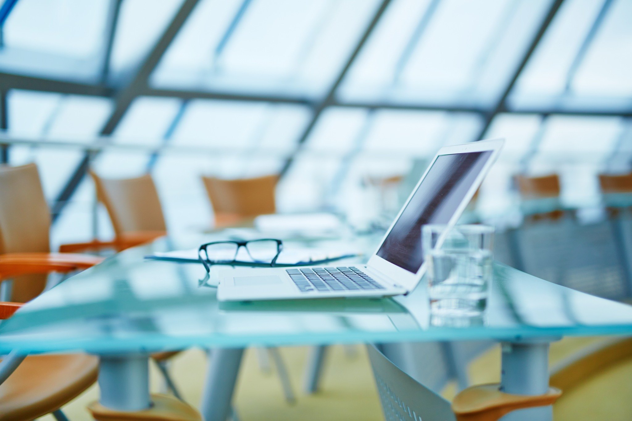 A quiet advisory meeting room with laptop and glass of water